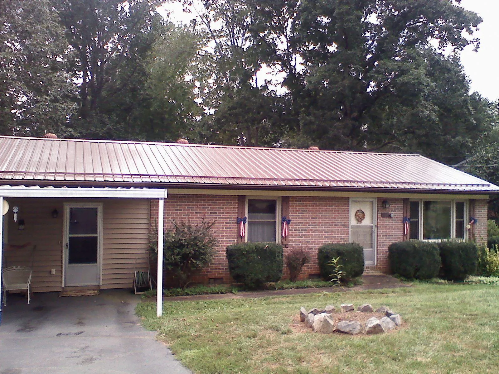 Bronze metal roof and carport on a brick ranch home — Roof Repair work by our crew in Underwood